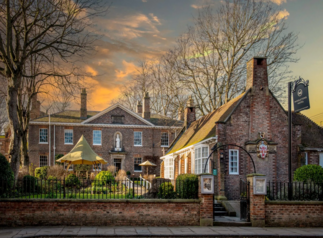 historic brick building with garden and sunset