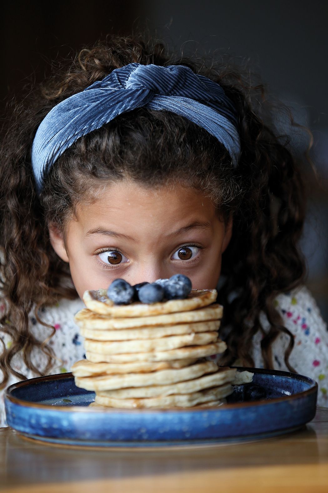 Child with a stack of pancakes